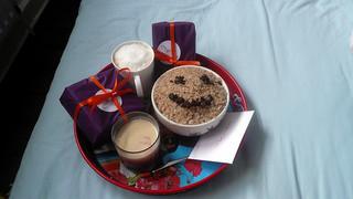 birthday breakfast in bed with gifts and smily face cereal
