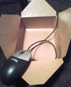 Computer mouse emerging from a box