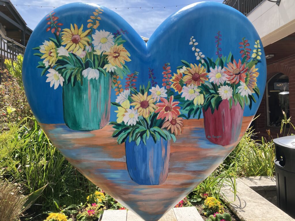 Painted heart sculpture in someone's yard.
