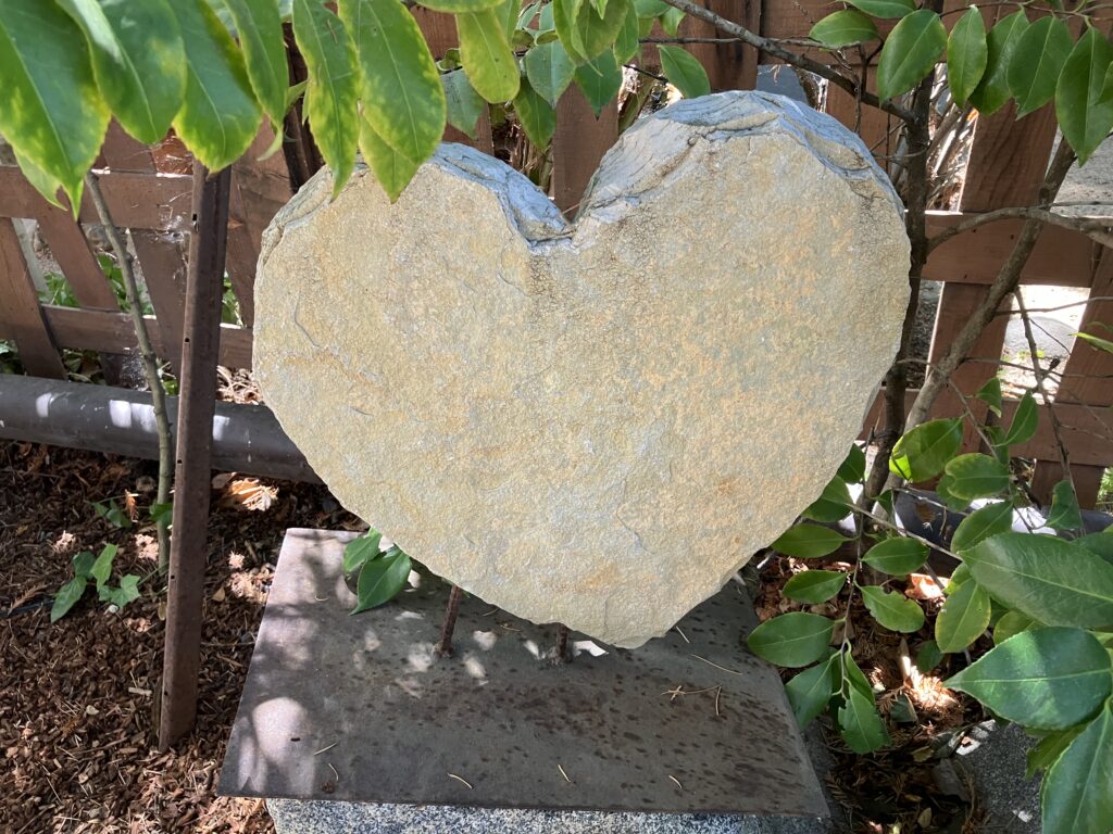 Stone heart tucked in a garden.