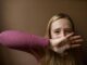 Woman showing "help" written on hand
