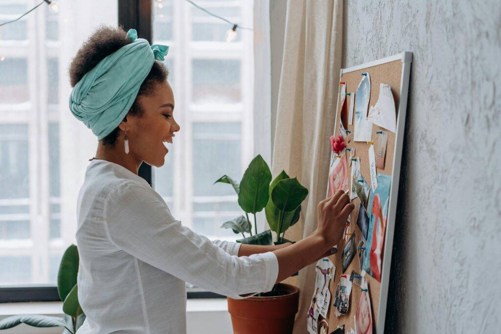 Woman planning, pinning images to a bulletin board