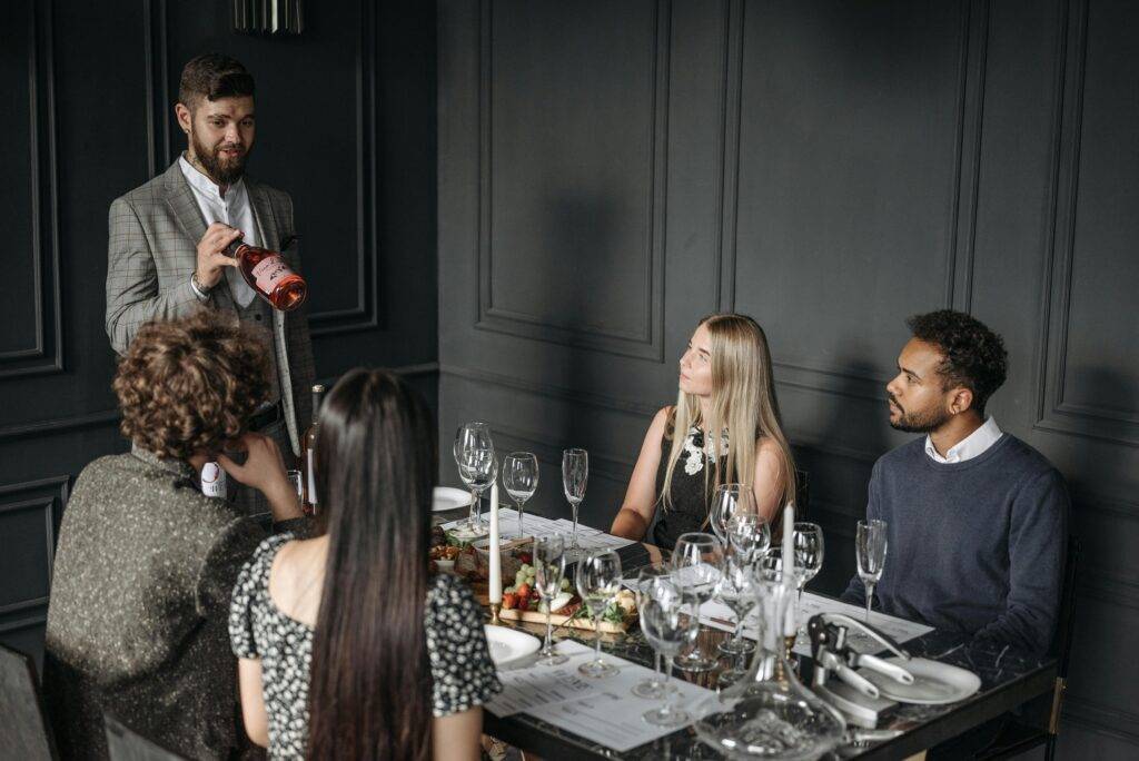 Sommelier serving two couples
