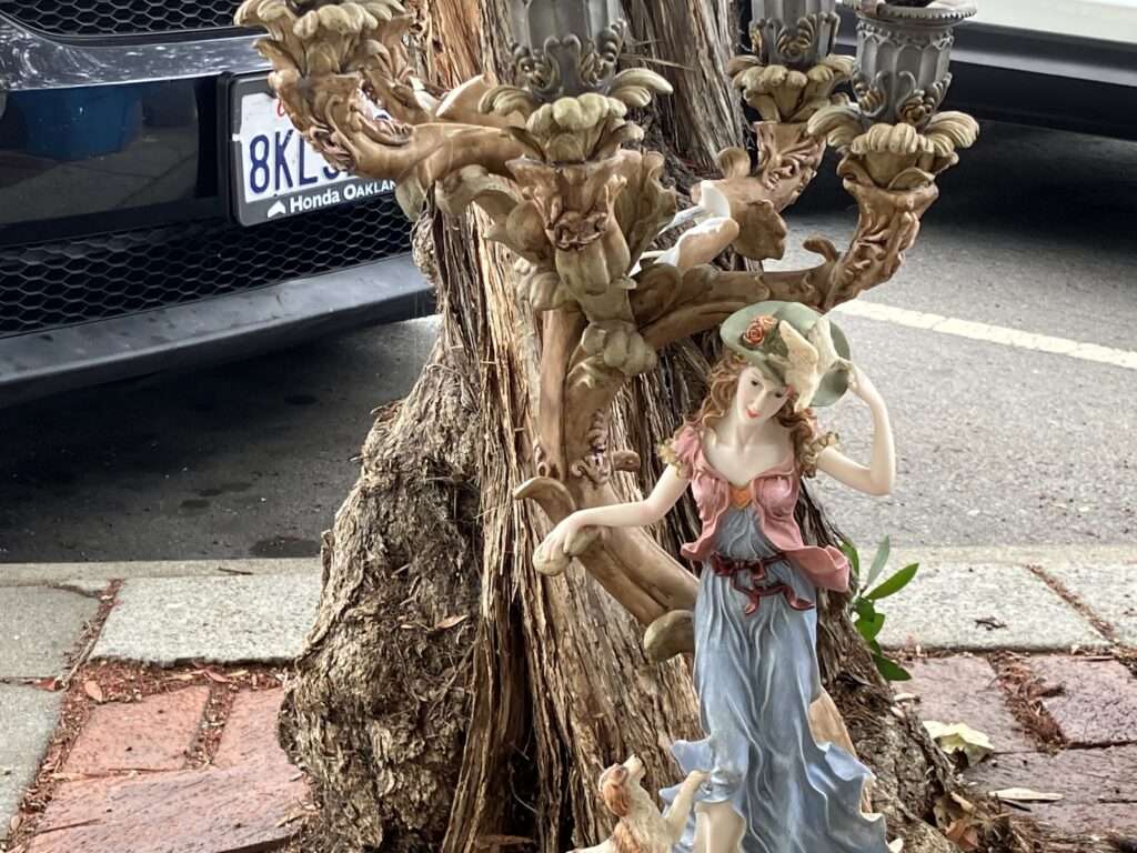 Abandoned lamp or candelabra by the side of a tree.