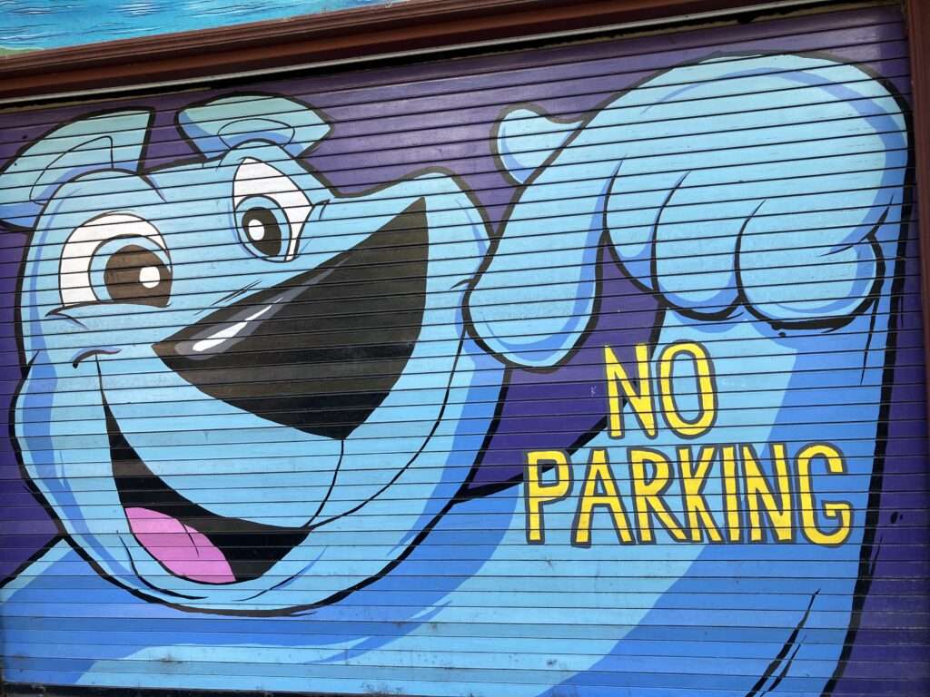 Doggie themed "No Parking" mural on a residential garage.